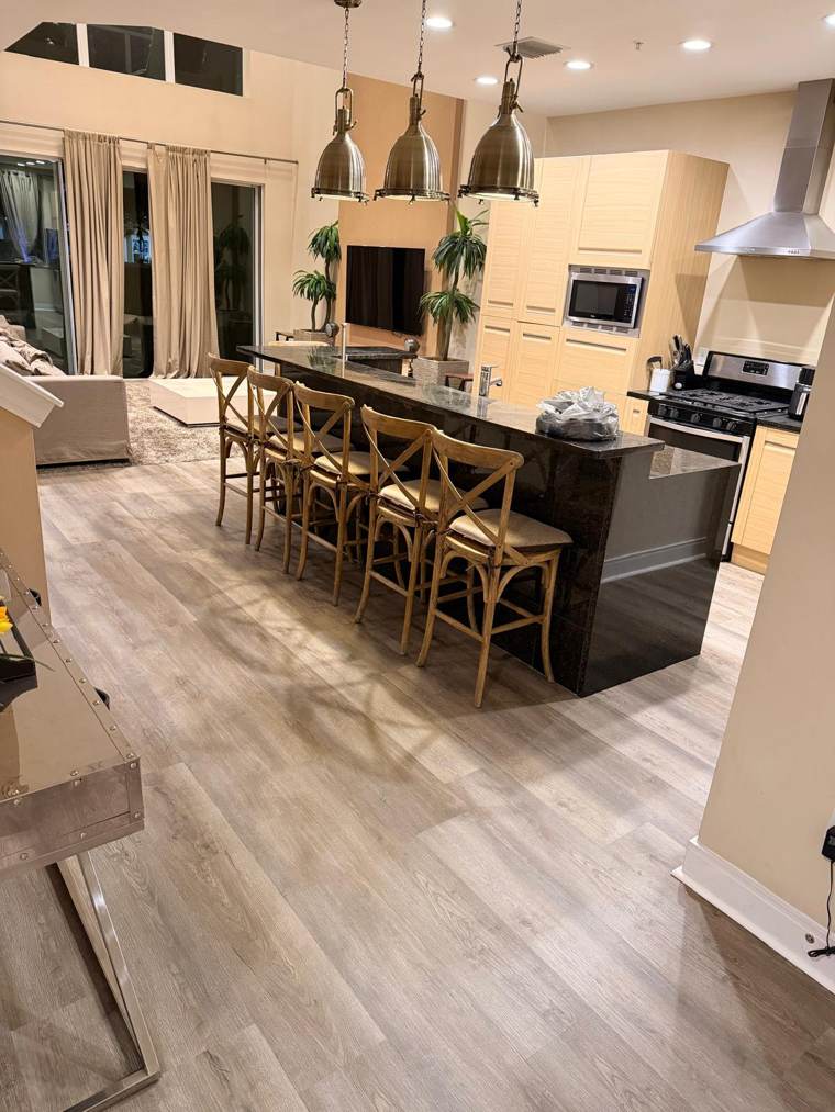 Gray wood-look vinyl plank floor in a kitchen and living room